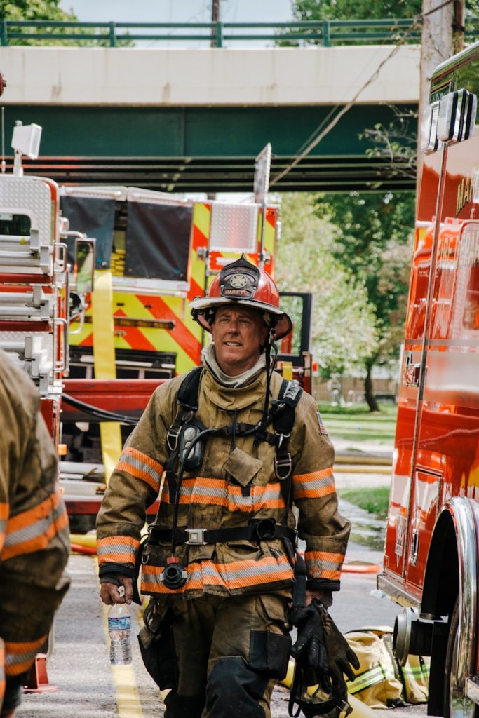 a fireman walking down a street next to a fire truck